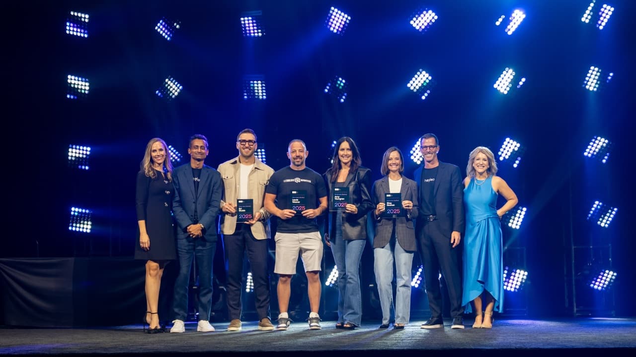 Amy on stage accepting a 2025 award alongside fellow honourees