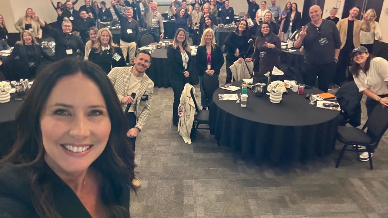 Amy's selfie with a room full of community members